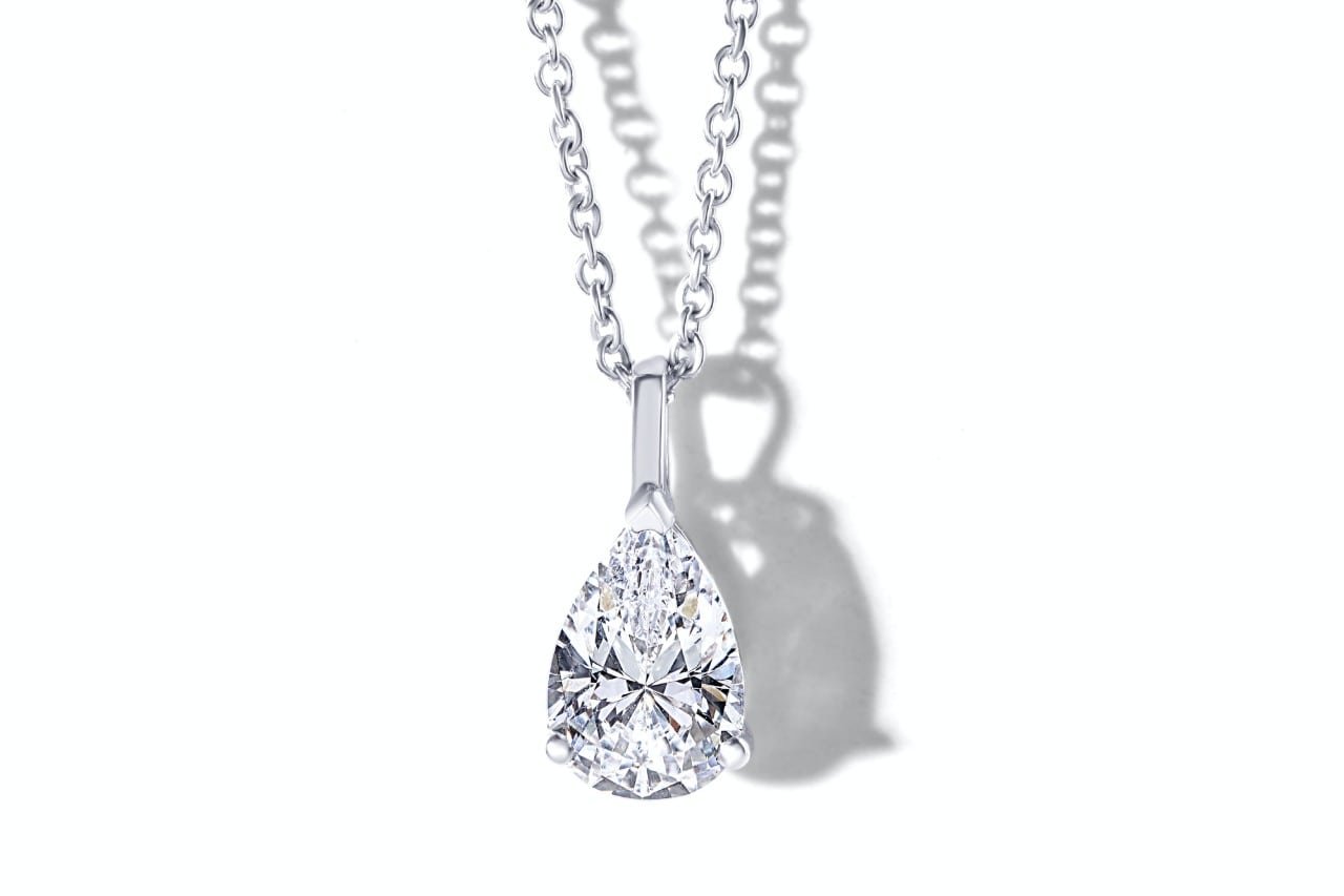 A pear-shaped diamond pendant against a white background.