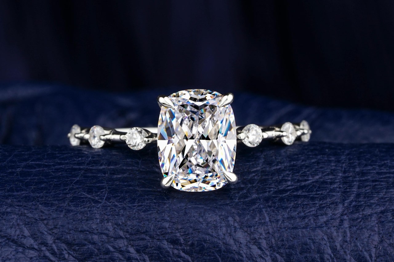 close up image of a diamond engagement ring with a large center stone sitting on black leather