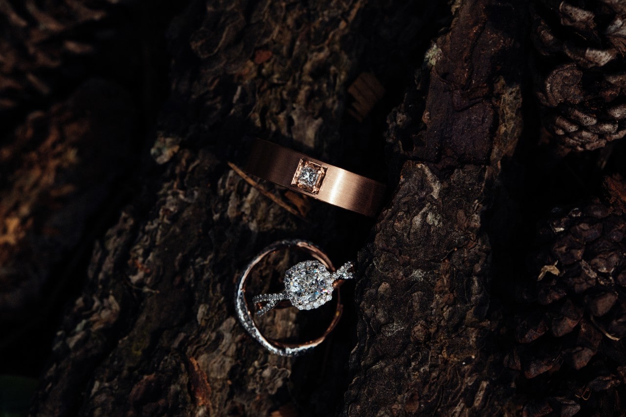 Old world cuts included in an engagement ring and wedding band shown against wood grain