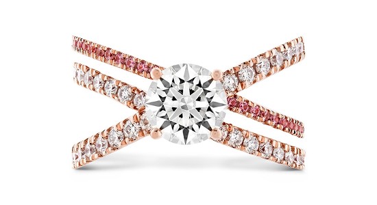a triple banded, rose gold engagement ring with a round cut center stone and diamond and pink sapphire side stones