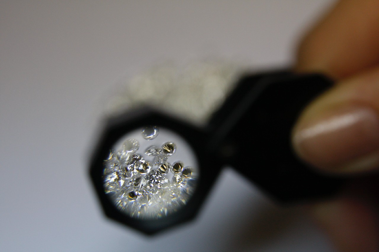 a person looking at diamonds with a small magnifying glass