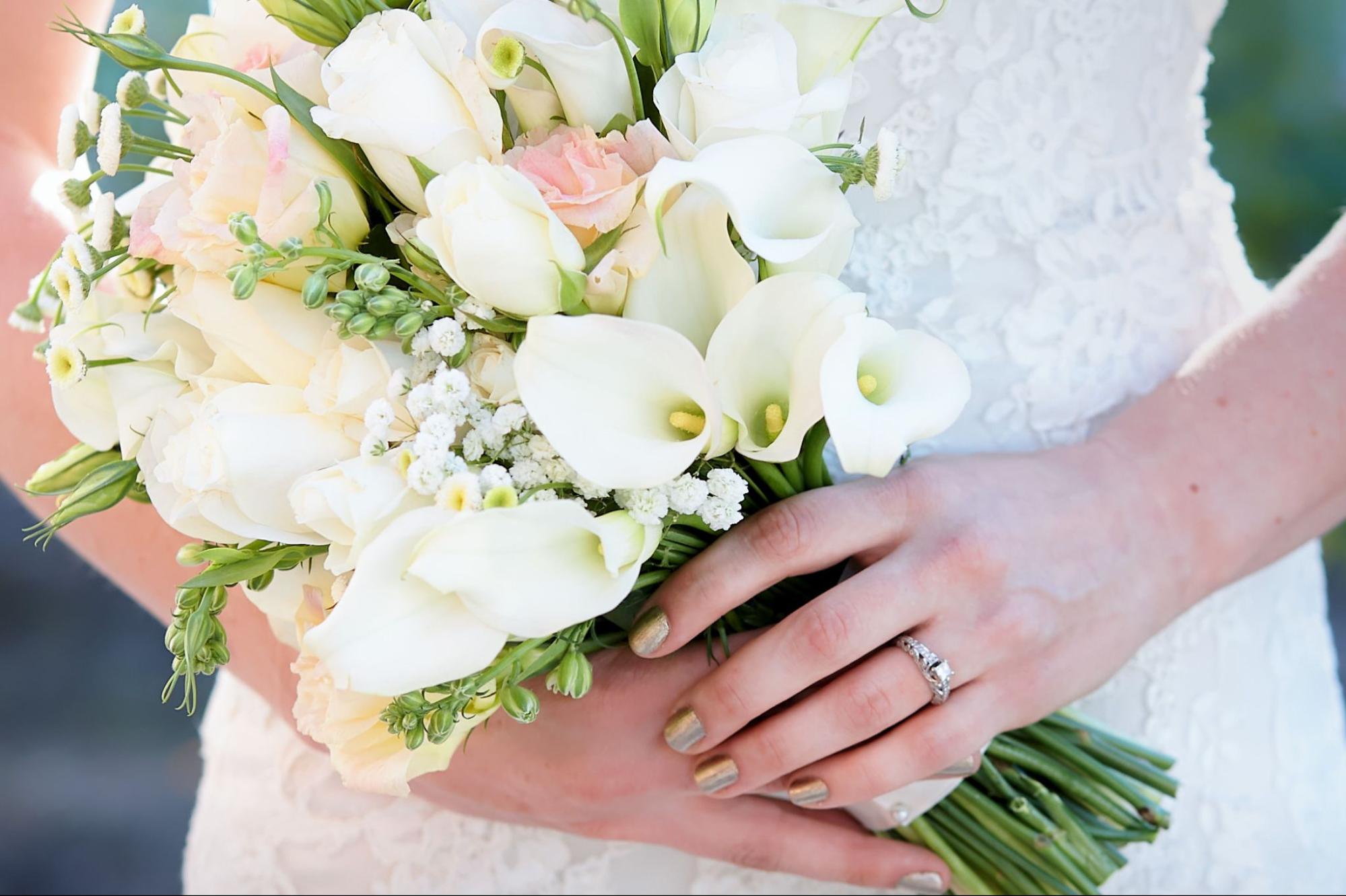 A close up of a bride holding up a bouquet.