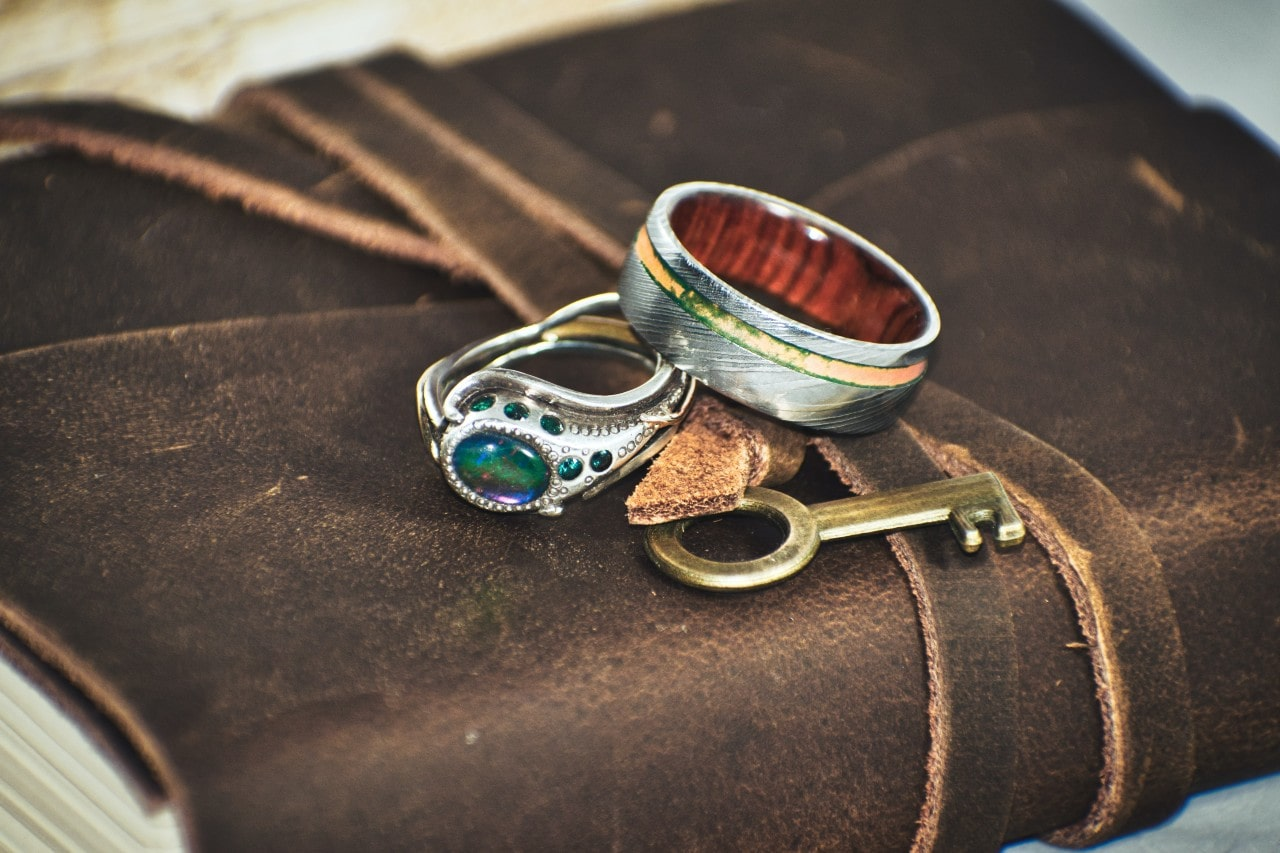 rings sitting on top of a journal with a key