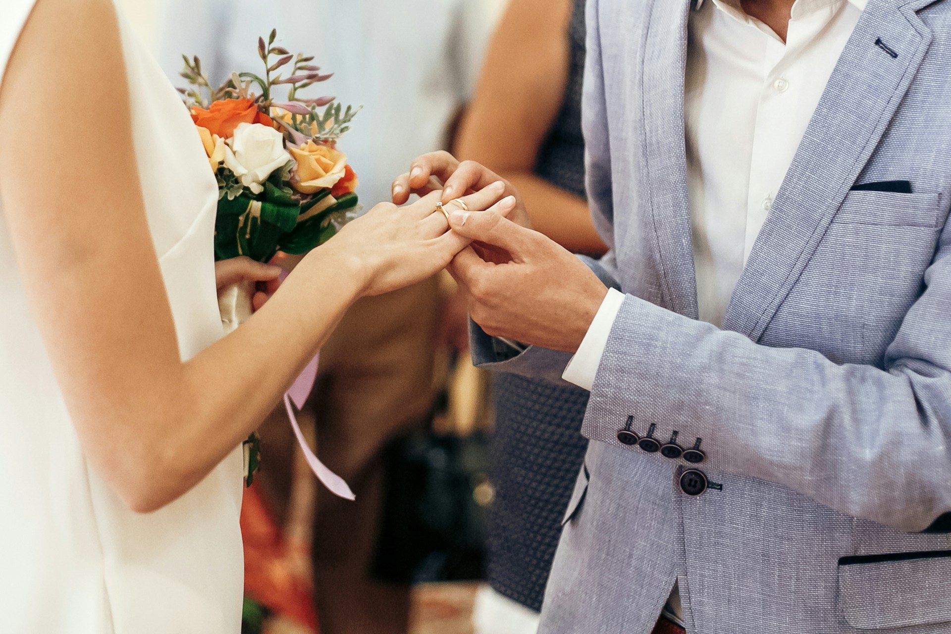 a man putting a wedding ring on a lady’s finger a man putting a wedding ring on a lady’s finger