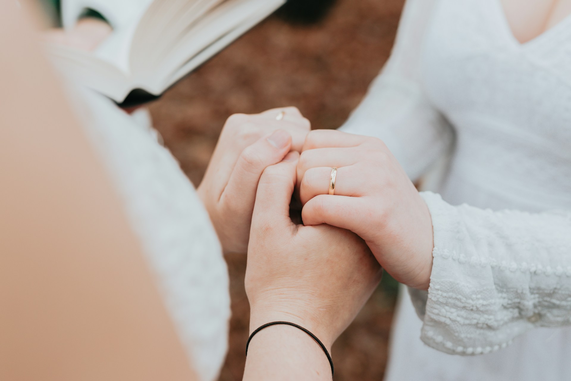 a couple holding hands and showing their wedding bands a couple holding hands and showing their wedding bands