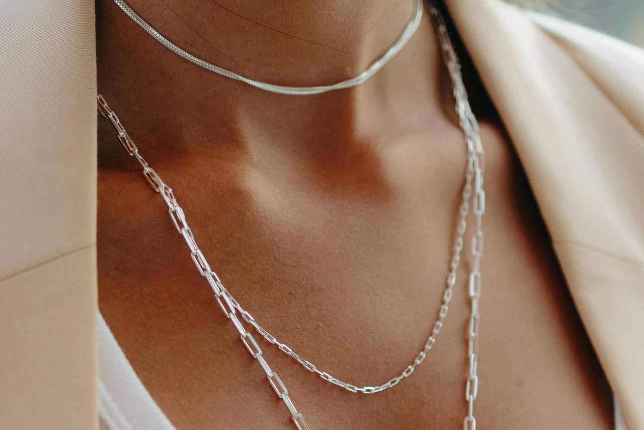 A woman wearing three dainty platinum chain necklaces A woman wearing three dainty platinum chain necklaces