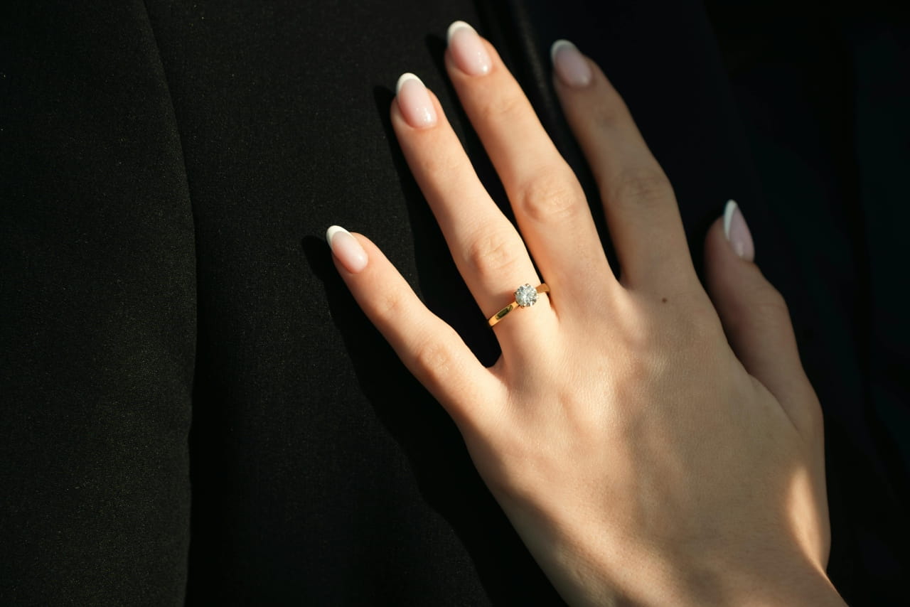 close up of woman's hands wearing solitaire engagement ring close up of woman's hands wearing solitaire engagement ring