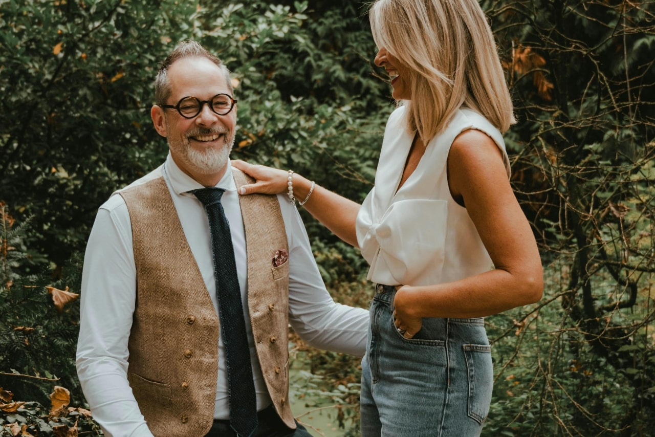 A laughing couple outdoors, highlighting a classic pearl bracelet and matching chain on the woman's wrist. A laughing couple outdoors, highlighting a classic pearl bracelet and matching chain on the woman's wrist.