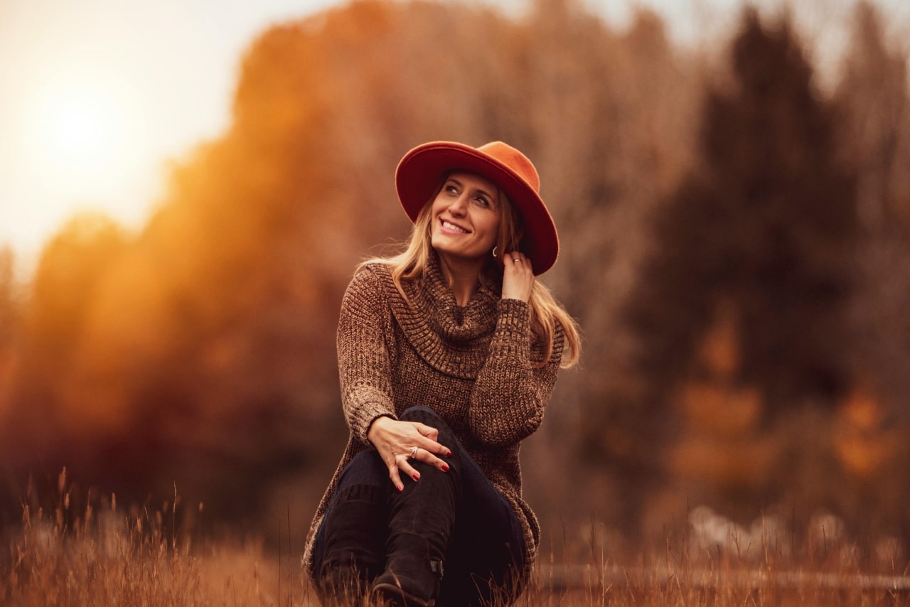 A smiling woman showing a white gold ring and hoop earrings in the sunset. A smiling woman showing a white gold ring and hoop earrings in the sunset.