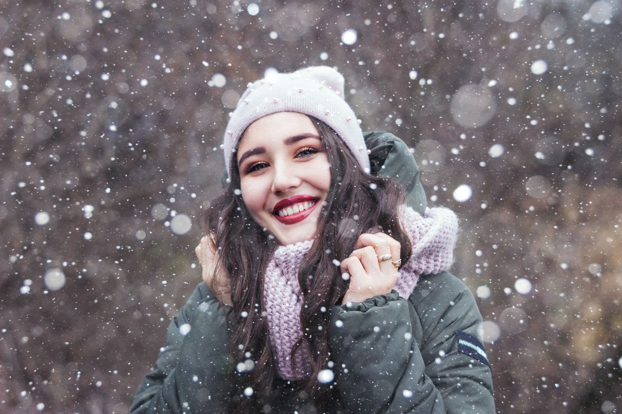 lady standing in the snow wearing fine jewelry and winter clothes