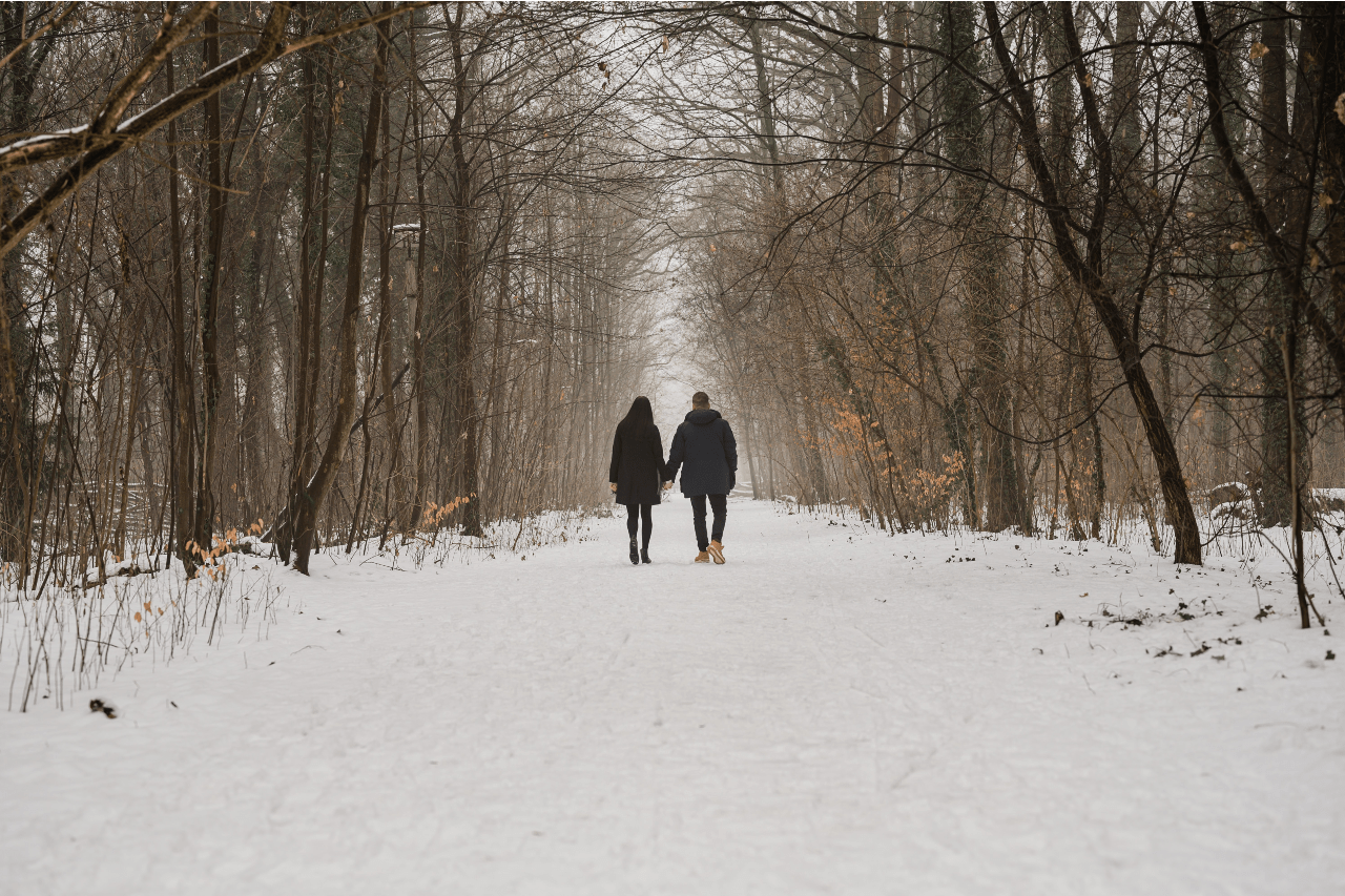 a couple holding hands walking in the snow a couple holding hands walking in the snow